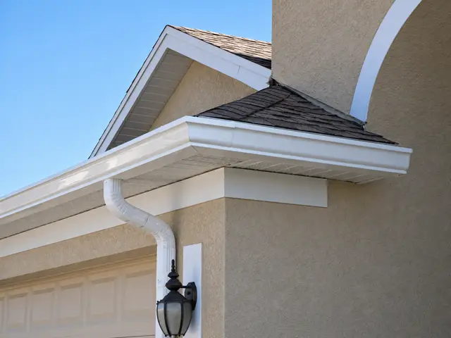 A white seamless gutter and downspout
